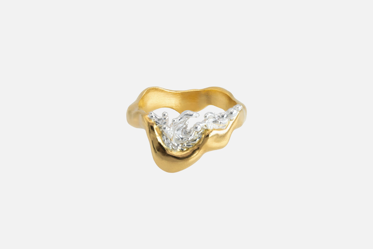 A gold vermeil and silver ring with a wavy, organic shape and a splash of water crafted in silver in the center.