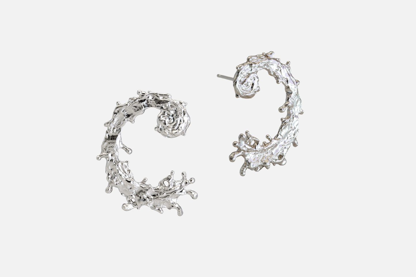 A pair of silver earrings with a textured, organic design like the waters of the sea swirling in a circular pattern, displayed on a clean light gray background.