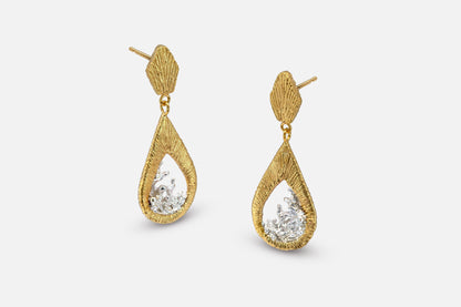 A pair of gold vermeil and silver teardrop dangle earrings with a textured, ribbed gold top and a water shaped silver center, shown against a light gray background.