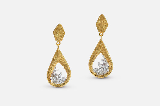 A pair of gold vermeil and silver teardrop dangle earrings with a textured, ribbed gold top and a water shaped silver center, shown against a light gray background.